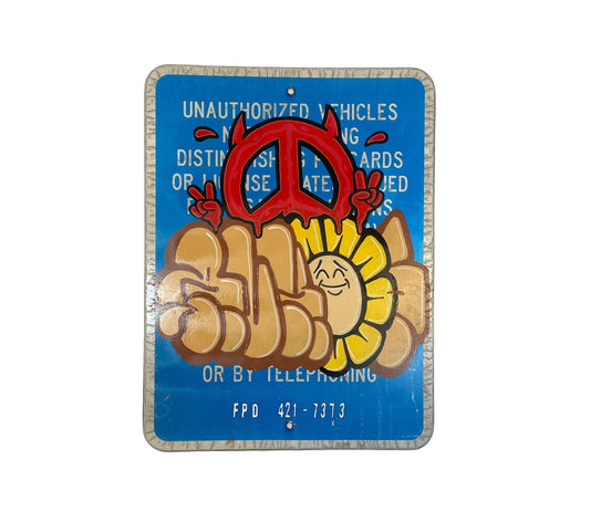 Decorative sign with peace symbol, hand, and sun design on a blue background.
